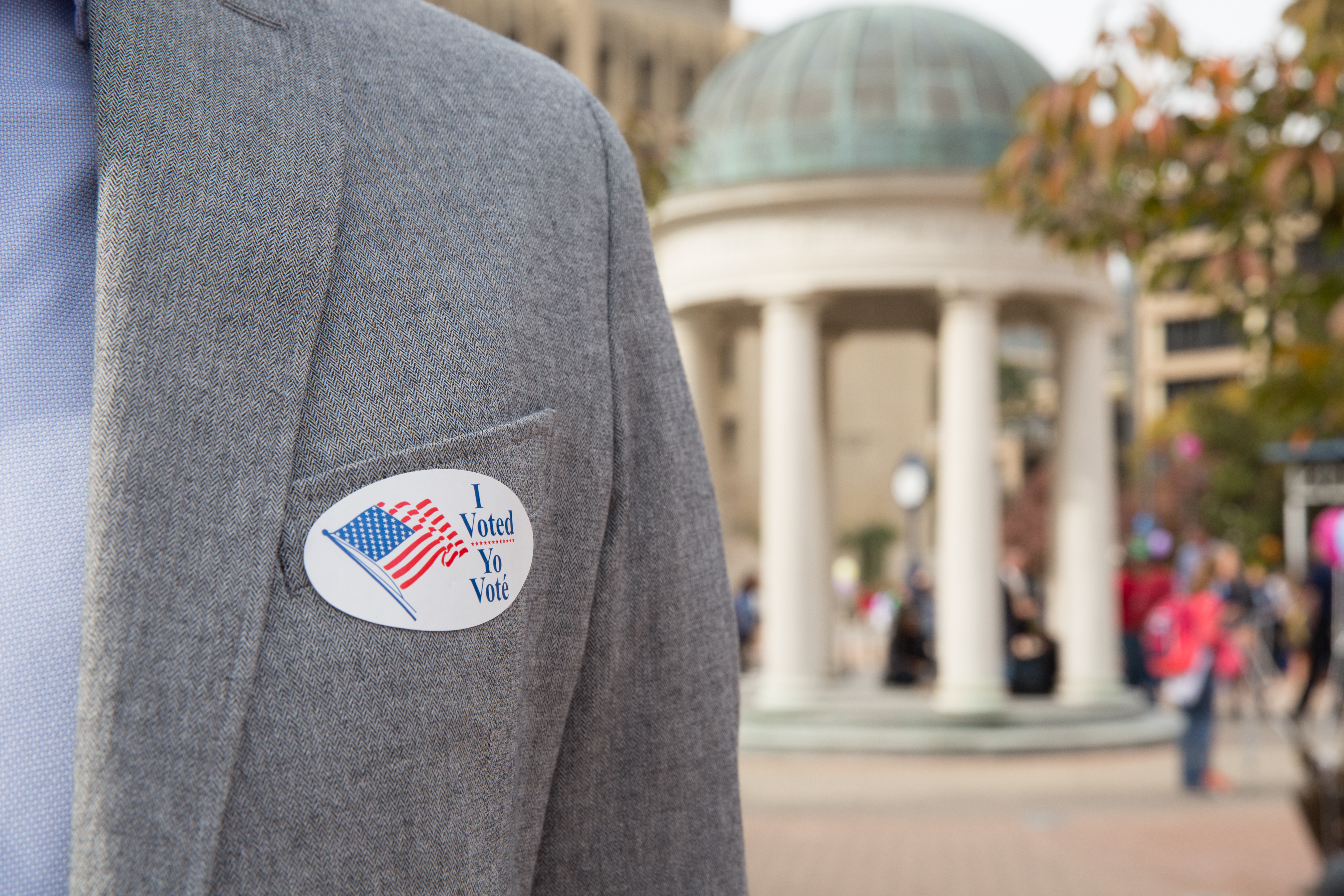 Individual wearing an "I Voted" sticker standing in Kogan Plaza.