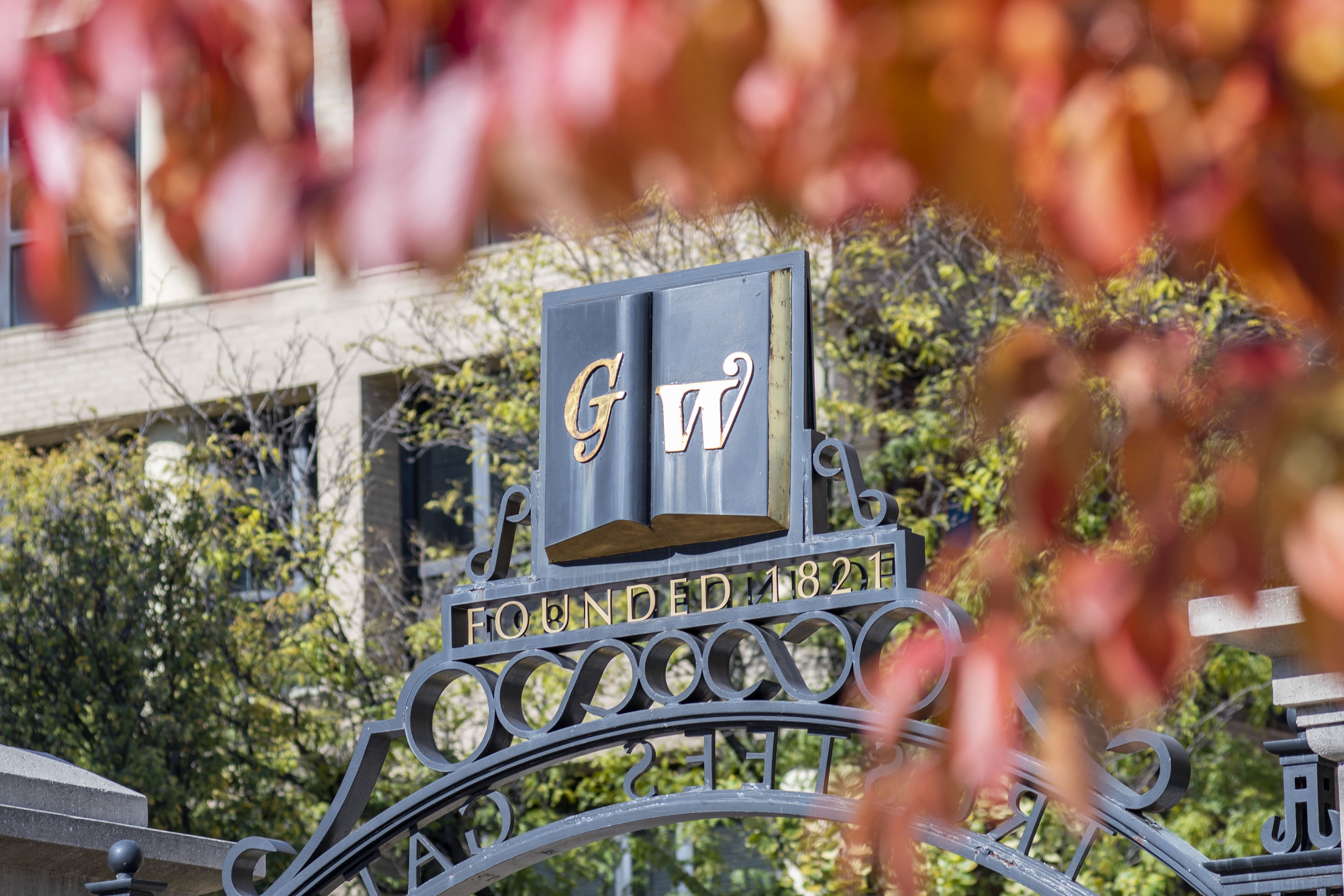 GW Founder Gates viewed through fall leaves.