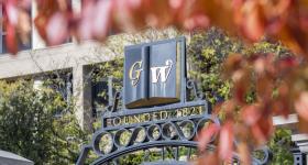 GW Founder Gates viewed through fall leaves.