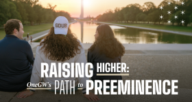 Raising Higher: One GW's Path to Preeminence | three GW student look off towards the sunset on the Washington Monument